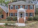Brick home with black shutters, white trimmed porch and brick stairs leading to a glass front door at 235 Scalybark Rd, Summerville, SC 29485