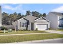 Attractive gray home with a two-car garage and a well-kept lawn on a sunny day at 259 N Light Way, Summerville, SC 29486