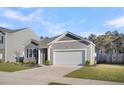 Well-maintained gray home featuring a two-car garage, green lawn, and tasteful landscaping at 259 N Light Way, Summerville, SC 29486