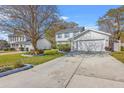 Attractive two-story home with a two-car garage, lush lawn, and a spacious driveway at 303 Axeminster Ct, Goose Creek, SC 29445