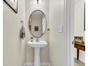 A cozy powder room featuring pedestal sink, oval mirror and neutral decor at 303 Pine Bluff Dr, Summerville, SC 29483