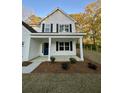 Welcoming front porch featuring white columns, dark shutters, and a vibrant blue front door, complementing the neutral exterior at 312 Woodland Shores Rd, Charleston, SC 29412