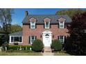Classic brick home with a white front door framed by manicured bushes and black shutters at 4 Chadwick Dr, Charleston, SC 29407
