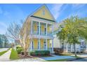 Attractive two-story yellow home featuring a double front porch and beautifully landscaped front yard at 401 Forsythia Ave, Summerville, SC 29483