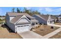 Angle view of gray house with a two-car garage, front porch, and simple landscape at 4075 Aspera Dr, Summerville, SC 29483