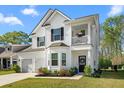 Charming two-story home with a two-car garage, a balcony, and a well-manicured front yard at 6005 Coral Berry Rd, Hanahan, SC 29410