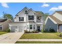 Charming two-story home with a two-car garage, a balcony, and a well-manicured front yard at 6005 Coral Berry Rd, Hanahan, SC 29410