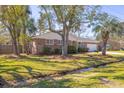 A charming single-story brick home with a well-maintained lawn and mature trees by a small creek at 689 Port Cir, Charleston, SC 29412