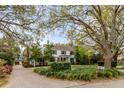 Beautiful home with a long brick driveway, mature trees, and manicured landscaping at 7 Guerard Rd, Charleston, SC 29407