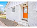 Close-up of a painted brick home with a bright orange front door and modern light fixture at 7665 Picardy Pl, North Charleston, SC 29420