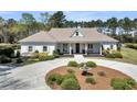Beautiful home with a circular driveway, fountain, manicured landscaping, and inviting entrance at 7858 Gull Bay Dr, Awendaw, SC 29429
