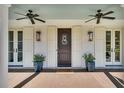 Charming front porch with double doors, stylish lighting, and potted plants at 7858 Gull Bay Dr, Awendaw, SC 29429