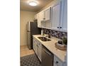 Galley kitchen featuring white cabinets, stainless steel appliances and a mosaic backsplash at 7945 Edgebrook Cir # B, North Charleston, SC 29418