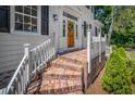 Inviting front porch with brick steps, white railings, and a wreath on the wooden front door at 914 S Main St, Summerville, SC 29483