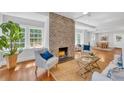 Bright living room with hardwood floors, brick fireplace, and a view into the dining area at 914 S Main St, Summerville, SC 29483