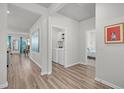 Inviting hallway showcases modern wood-look flooring, a laundry room, and leads to a sunlit living area and cozy bedroom at 9700 Flooded Field Drive Dr, Ladson, SC 29456