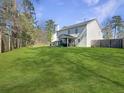 Expansive backyard featuring a lush lawn, a screened-in porch, and mature trees for privacy at 104 Salem Rd, Ladson, SC 29456