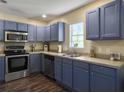 Stylish kitchen with stainless steel appliances, custom cabinets, and a view of the backyard at 104 Salem Rd, Ladson, SC 29456
