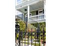 Elegant curved stairs leading to the porch, framed by lush greenery and black iron railings at 106 Murray Blvd, Charleston, SC 29401