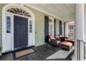 Inviting front porch with dark wood flooring, comfortable seating, and stylish decor at 106 Murray Blvd, Charleston, SC 29401