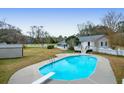 Backyard swimming pool with diving board, shed, and white fencing surrounding property at 1158 Wildgame Rd, Summerville, SC 29486