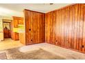 Cozy living room with wood paneling and carpet floors, flowing into the kitchen at 1198 Oakcrest Dr, Charleston, SC 29412