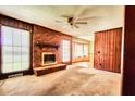 Spacious living room with a brick fireplace, wood paneling, and natural light at 1198 Oakcrest Dr, Charleston, SC 29412