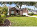 Attractive red brick home featuring a well-kept lawn and a convenient two-car attached garage at 1232 Palmetto Peninsula Dr, Mount Pleasant, SC 29464