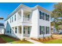 Inviting two-story home boasts a double covered porch, a well-manicured lawn, and a modern white facade at 125 Cantona Dr, Summerville, SC 29483