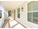 Covered front porch provides a shady retreat, accentuated by stylish lighting and a glimpse of the entry door at 125 Cantona Dr, Summerville, SC 29483
