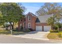 Classic two-story brick home showcasing a well-kept lawn and a two-car attached garage at 1324 Southlake Dr, Mount Pleasant, SC 29464