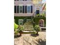 Inviting front entrance with a curved stairway, decorative flower pots, and lush greenery at 14 Greenhill St, Charleston, SC 29401
