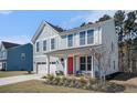Charming two-story home with light blue siding, white trim, and a bright red front door at 1427 Homecoming Blvd, Ravenel, SC 29470