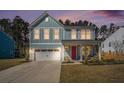 Charming two-story home with light blue siding, white trim, and a bright red front door at twilight at 1427 Homecoming Blvd, Ravenel, SC 29470