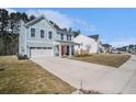 Charming two-story home with light blue siding, white trim, and a long driveway at 1427 Homecoming Blvd, Ravenel, SC 29470