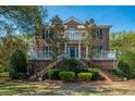 Elegant brick home with inviting double porches, landscaped yard, and stately facade at 1521 Hurtes Island Dr, Charleston, SC 29407