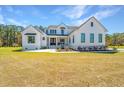 Charming two-story farmhouse with black trim, a cozy porch, and a manicured lawn at 161 Ryefield Ln, Ridgeville, SC 29472