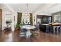 Bright dining area with dark hardwood floors, modern light fixture, and an adjacent open-concept kitchen at 1810 Fleming Woods Rd, Charleston, SC 29412