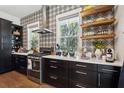 Well-lit kitchen with stainless steel appliances, a stylish backsplash, and open shelving for a modern feel at 1810 Fleming Woods Rd, Charleston, SC 29412