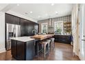 Stylish kitchen featuring dark cabinetry, a butcher block island with seating, and stainless steel appliances at 1810 Fleming Woods Rd, Charleston, SC 29412