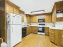 Traditional kitchen featuring wood cabinets, black appliances, and hardwood floors at 1876 Chilhowee Dr, Johns Island, SC 29455