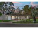 Charming single-story home with manicured landscaping at twilight featuring a lush lawn and mature trees at 201 Miami St, Ladson, SC 29456