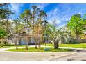 Daytime view of single-story home with a well maintained lawn, trees, and landscaping around the circular driveway at 201 Miami St, Ladson, SC 29456