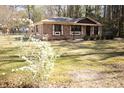 A cozy single-story home surrounded by a lush lawn and flowering shrubs at 208 Owens Dr, Summerville, SC 29485