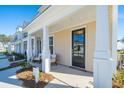 Inviting townhome front porch with white columns, seating, and black front door at 314 Green Fern Dr, Summerville, SC 29483