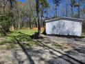 Large backyard with a grassy area, gravel groundcover, and a newly planted row of shrubbery at 4532 S Carolina # 41, Huger, SC 29450