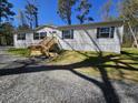 Beautiful single story home with a new front porch, well-manicured lawn, and gravel driveway at 4532 S Carolina # 41, Huger, SC 29450