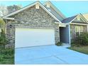Home exterior features a two-car garage, beautiful stonework and low maintenance landscaping at 482 Oak View Way, Summerville, SC 29483