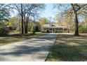 Inviting home with a long driveway, lush green lawn and mature trees creating a serene setting at 5367 Boone Run, Hollywood, SC 29449