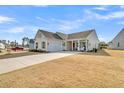 Inviting home with a two-car garage, lovely front porch, and green lawn at 663 Marsh Cove Cir, Summerville, SC 29486